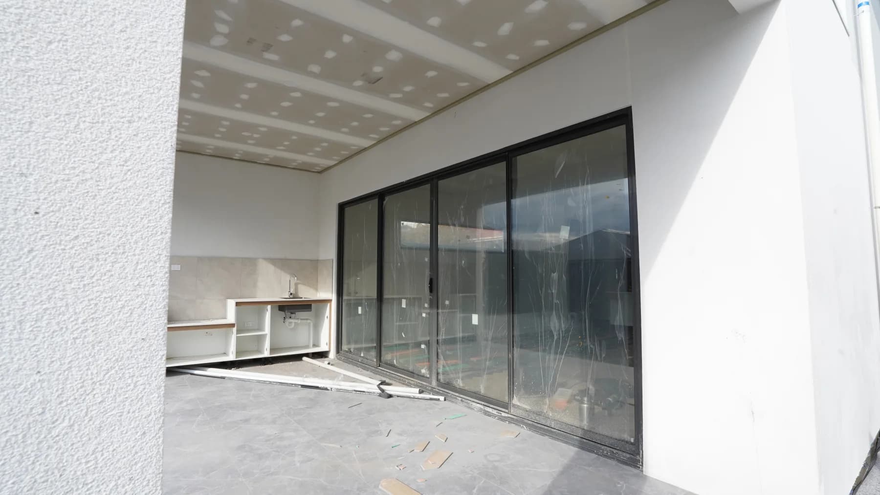 Large alfresco sliding door suite with dark aluminium frames